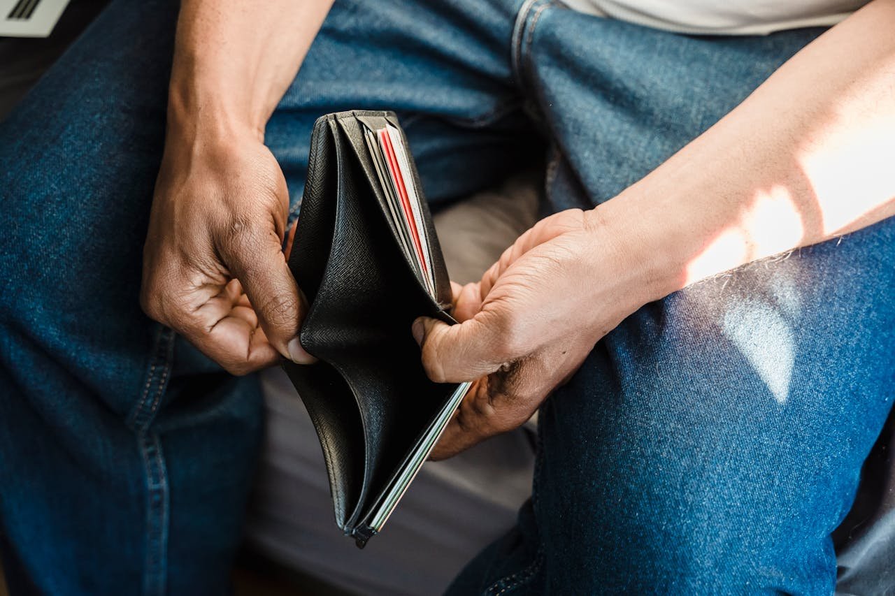 Un homme présente une porte-feuille vide